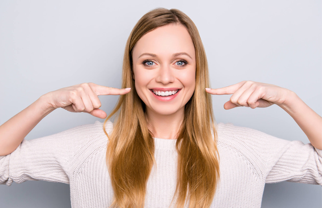 Patient showing bright white smile after professional teeth whitening treatment in Austin TX at Hapi Dental
