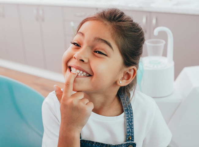 Child smiling during a restorative dentistry visit at Hapii Dental in Austin, TX.