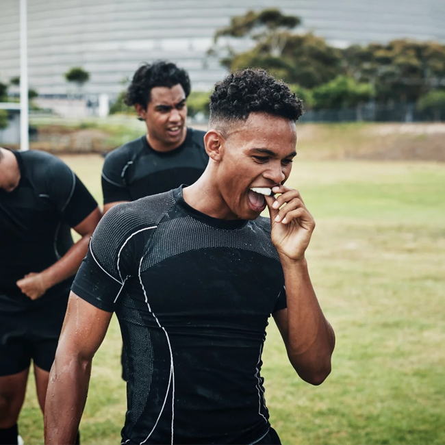 Athlete using a sports mouthguard for dental protection at Hapii Dental in Austin, TX.