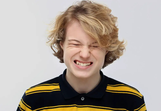 Teen clenching teeth showing symptoms of teeth grinding (bruxism) in Austin, TX
