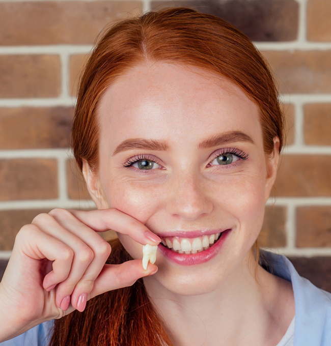 Patient holding an extracted tooth after professional tooth extraction treatment in Austin, TX